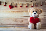 Fototapeta Pokój dzieciecy - Teddy bear holding a heart-shaped pillow