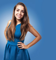 Wall Mural - gorgeous young woman wearing a dress on a blue background