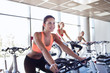 © Syda Productions - group of women riding on exercise bike in gym
