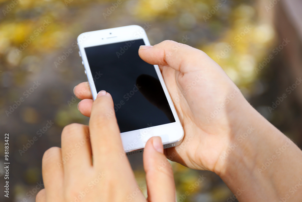 Woman holding smartphone outside