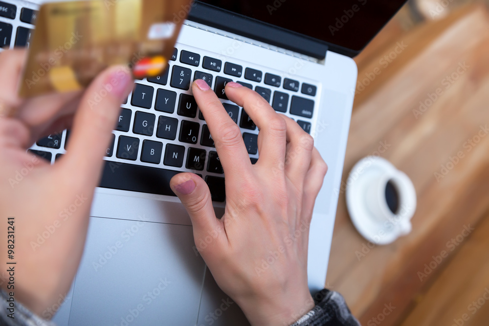 Hands of person entering credit Card Data on Laptop