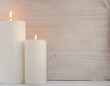 Thick white candles on the wooden background