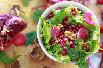 Top view of Curly endive salad with pomegranate, nuts...