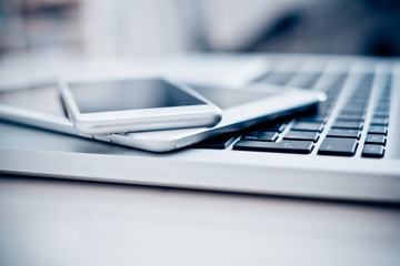 laptop with phone and tablet pc on white table