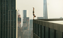 Man Performs A Handstand On The Edge Of A Skyscraper