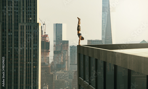 Cuadros en Lienzo Man performs a handstand on the edge of a skyscraper