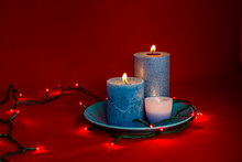 Blue Burning Candles With Lights On A Red Background