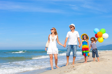 Canvas Print - Happy family playing  with balloons on the beach at the day time