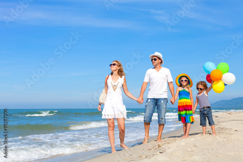 Plakat Szczęśliwa rodzina bawić się z balonami na plaży przy dnia czasem