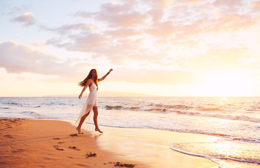 Wall Mural - Happy Carefree Woman Dancing on the Beach at Sunset