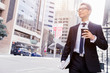 © Sergey Nivens - Businessman with coffee in a city