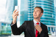 © fotofabrika - Handsome young businessman taking a selfie with a mobile phone