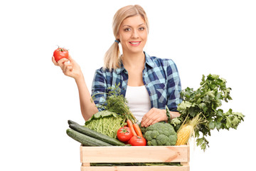 Poster - Woman standing behind a crate with vegetables