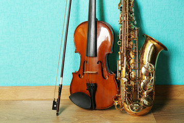 Wall Mural - Violin and saxophone on the floor against blue background