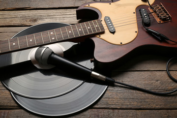 Wall Mural - Electric guitar and headphones with vinyl on wooden background