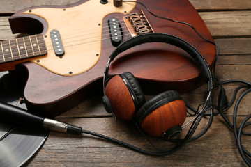 Canvas Print - Electric guitar and headphones on wooden background