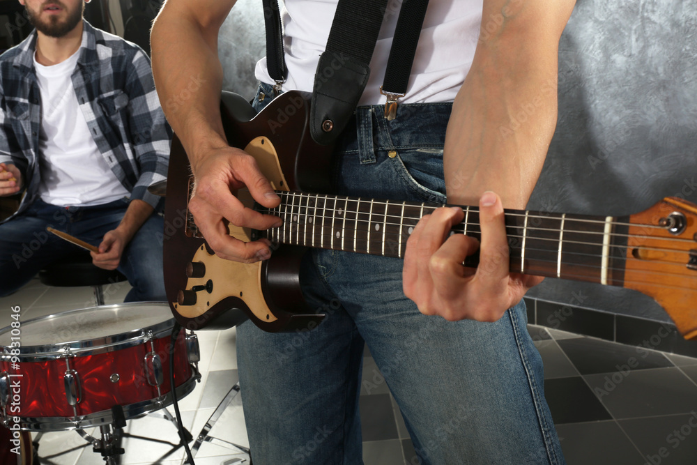 Young man paying guitar closeup