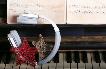 Wall Mural - Grey headphones with decorative stars on piano keyboard, close up