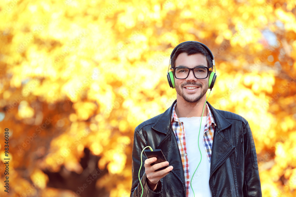 Young man in a park listening to music