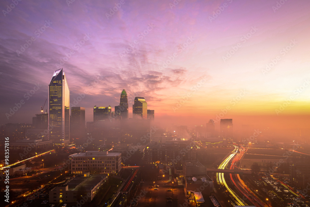 A foggy and colorful sunrise in Charlotte, North Carolina during the morning rush hour traffic.  - obrazy, fototapety, plakaty 