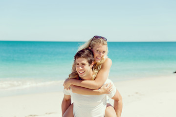 Portrait of man carrying girlfriend on his back