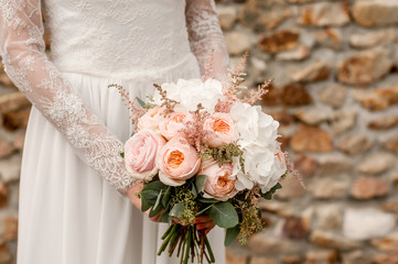 Beautiful wedding bouquet in the hands of the bride