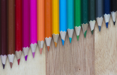 Coloured pencils against a wooden background