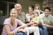 © Westend61 - Group picture of three generations family sitting on the terrace