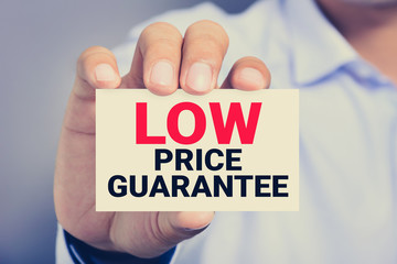 LOW PRICE GUARANTEE, message on the card shown by a man