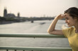 © Westend61 - Germany, Cologne, young woman standing on Rhine bridge at evening twilight