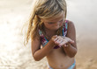 © Westend61 - Little girl on the beach with an lever on her hand