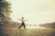 © Westend61 - Woman doing a moon salutation yoga pose in autumn park