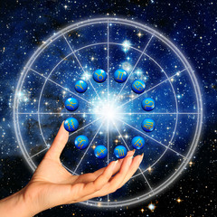 Wall Mural - hand holding an astrology wheel with zodiac signs