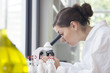 © Westend61 - Portrait of young female chemist looking through microscope