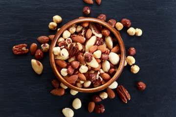 Wall Mural - mix nuts in wooden bowls on old blue stone background