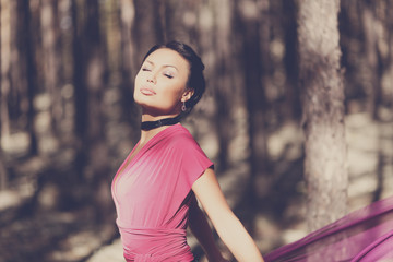 Beautiful kazakh woman in trendy dress in the forest