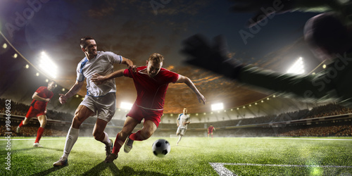 Obraz w ramie Soccer players in action on sunset stadium background panorama