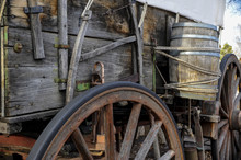 Side  View Of Pioneer Wagon With Wheel And Water Barrel 