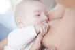 © WH_Pics - Baby holds her mom hand while he is breastfed