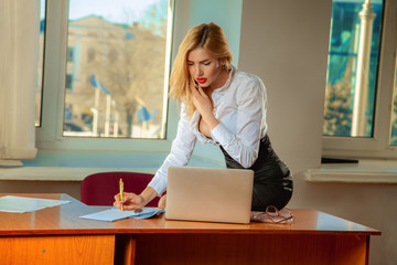 Business lady writes documents and talking phone in office