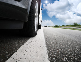 Wall Mural - Blurred car and blue sky with clouds