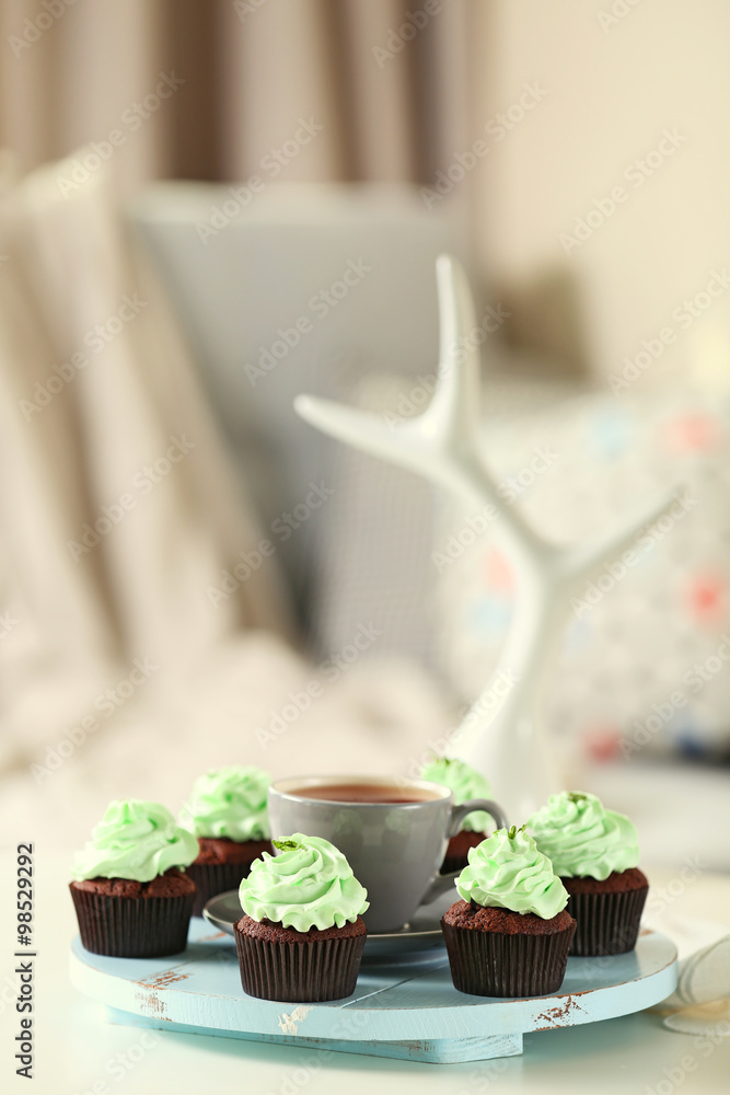 Beautiful chocolate cupcakes and cup of tea,  on table