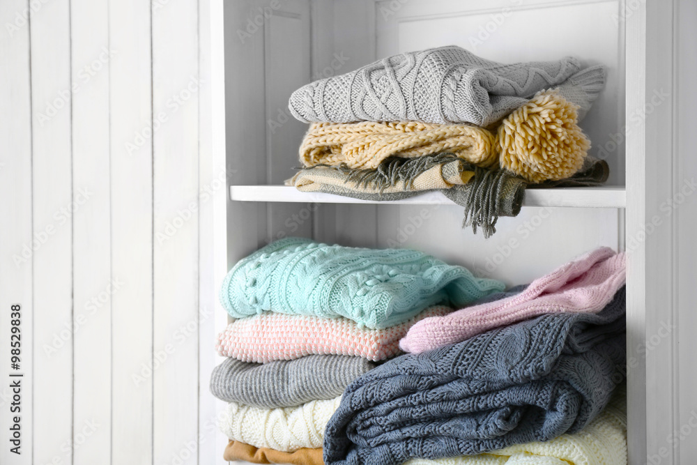 Knitting clothes on wooden shelf