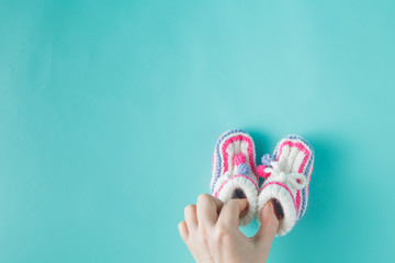 Hand holding tiny knitted booties