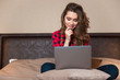 © Drobot Dean - Woman sitting on the bed and using laptop computer