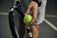 Close-up Of Male Hand Holding Tennis Ball And Racket. Professional Tennis Player Starting Set. 