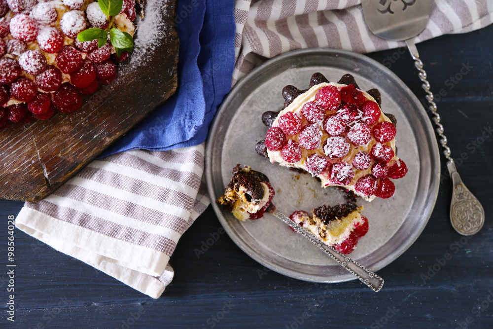Sweet cake with raspberries on color wooden background