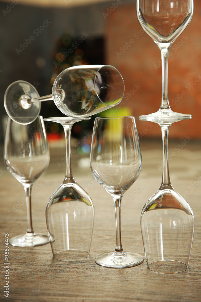 Construction of empty wine glasses on wooden table against blurred background