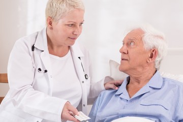 Wall Mural - Nurse giving pills to senior patient