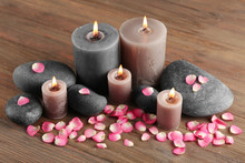 Alight Wax Grey Candle With Flower Petals And Pebbles On Wooden Background